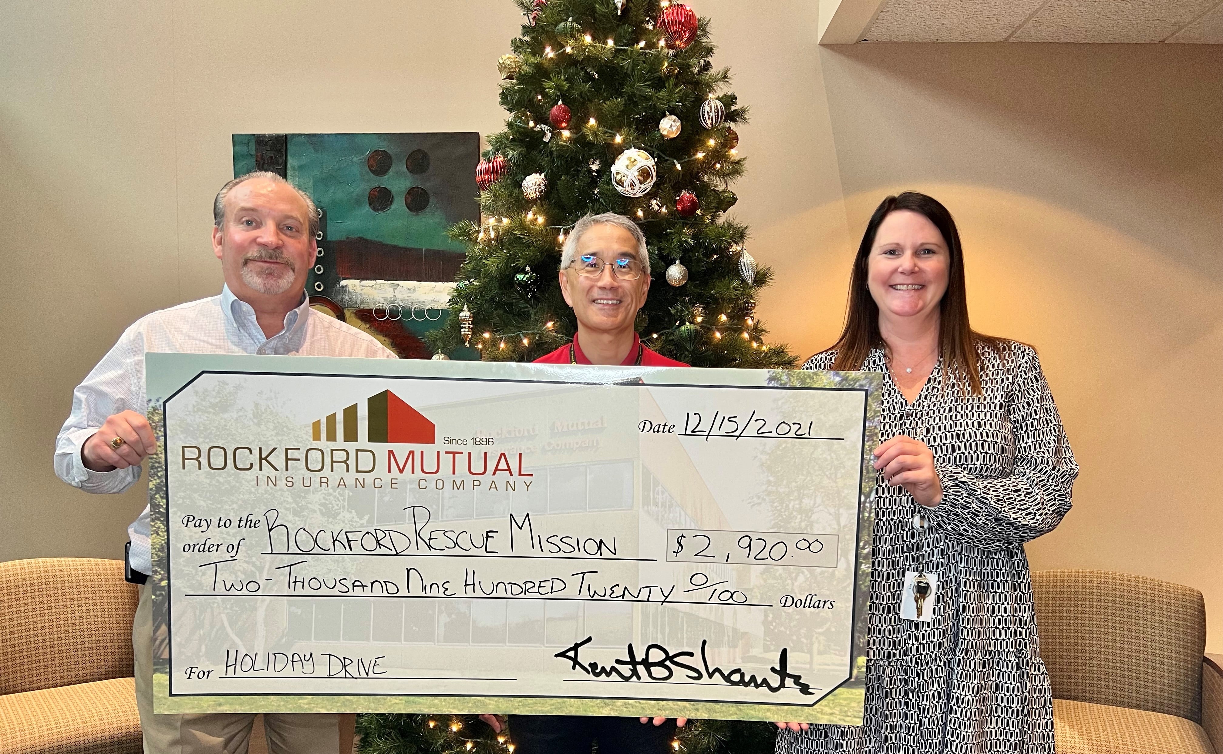 Three people holding big cheque