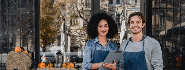 Business partners in front of store with pumpkins