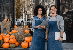 Business partners in front of store with pumpkins